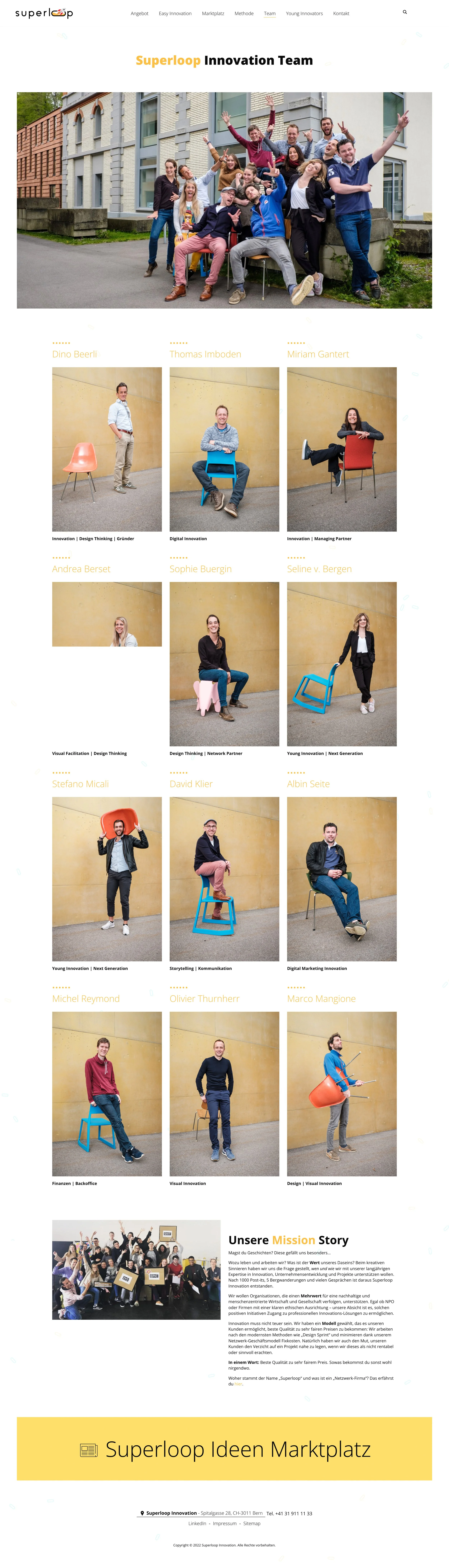 Gruppenfoto eines Teams vor einem Gebäude, lachend und mit den Armen in die Luft gestreckt, während einige Personen sitzend posieren, die meisten stehen.