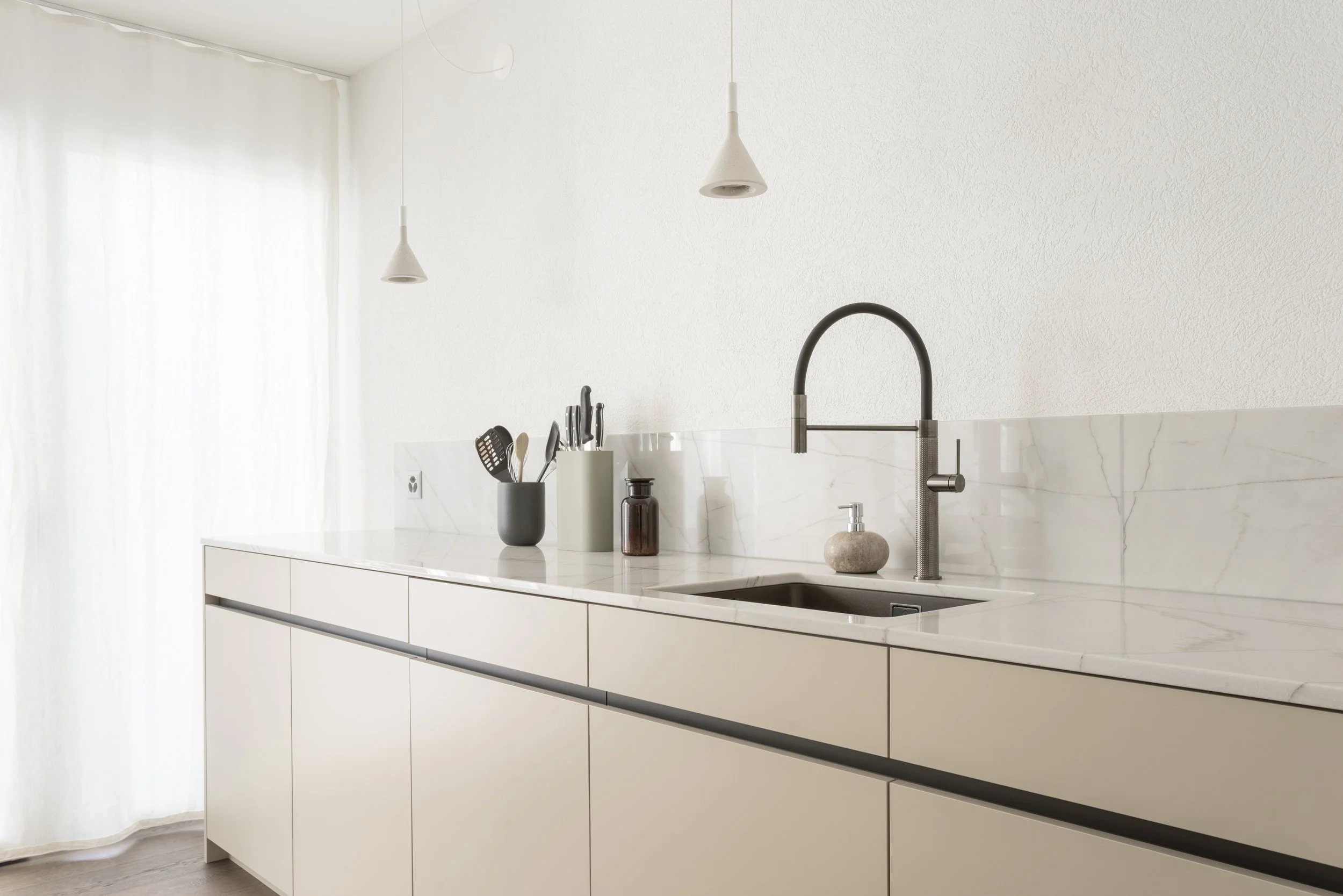 Moderne Küche mit weißer Knappheit, grauen Armaturen und minimalen Dekor